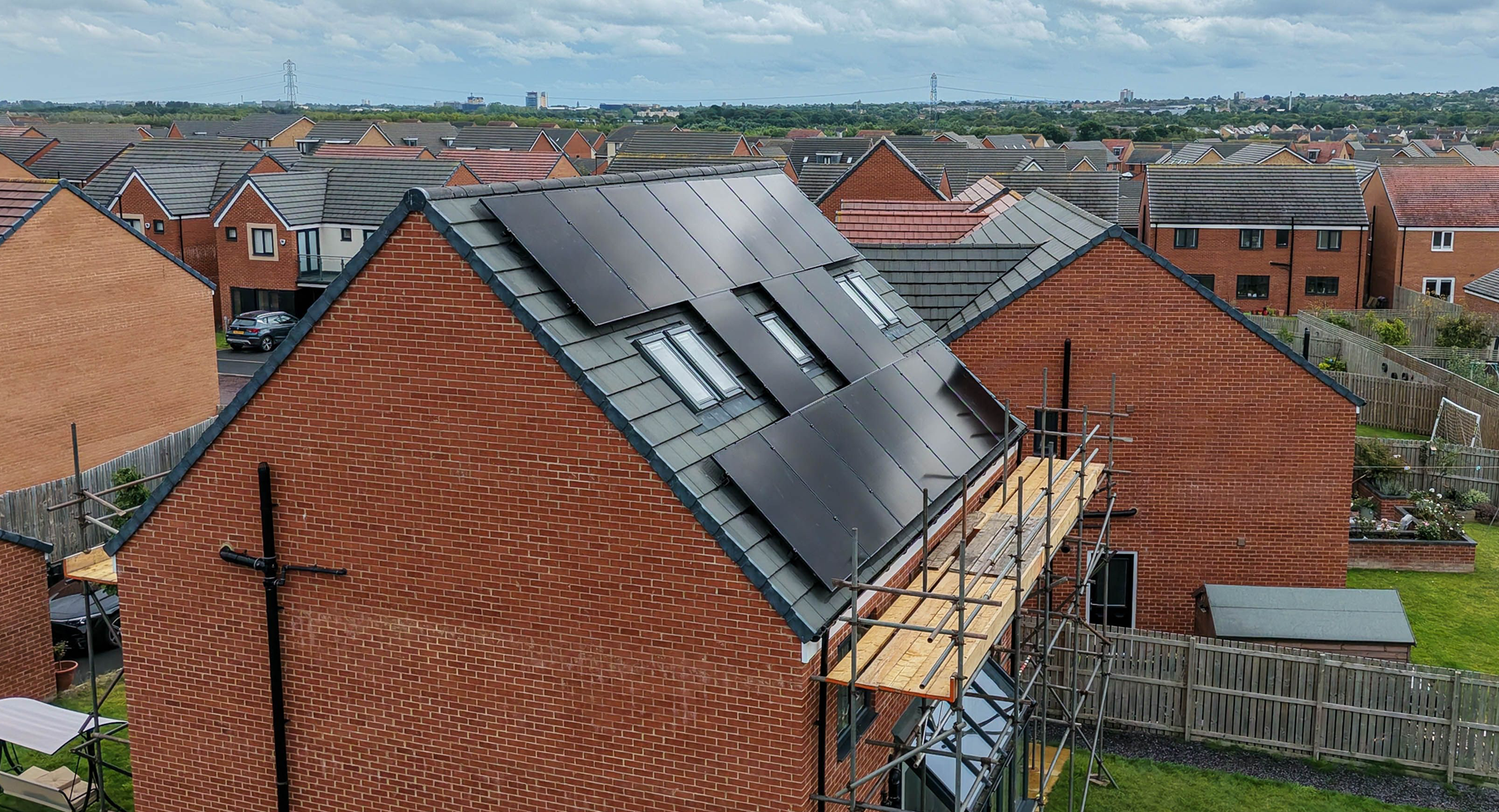 Solar panels installed around roof windows on a tiled house roof